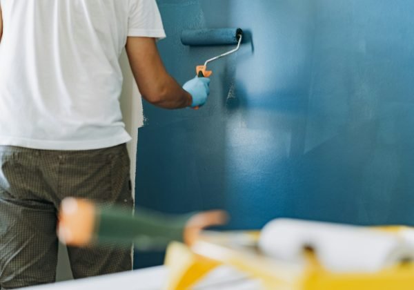 caucasian bearded man painting wall with paint roller. Painting apartment, renovating home